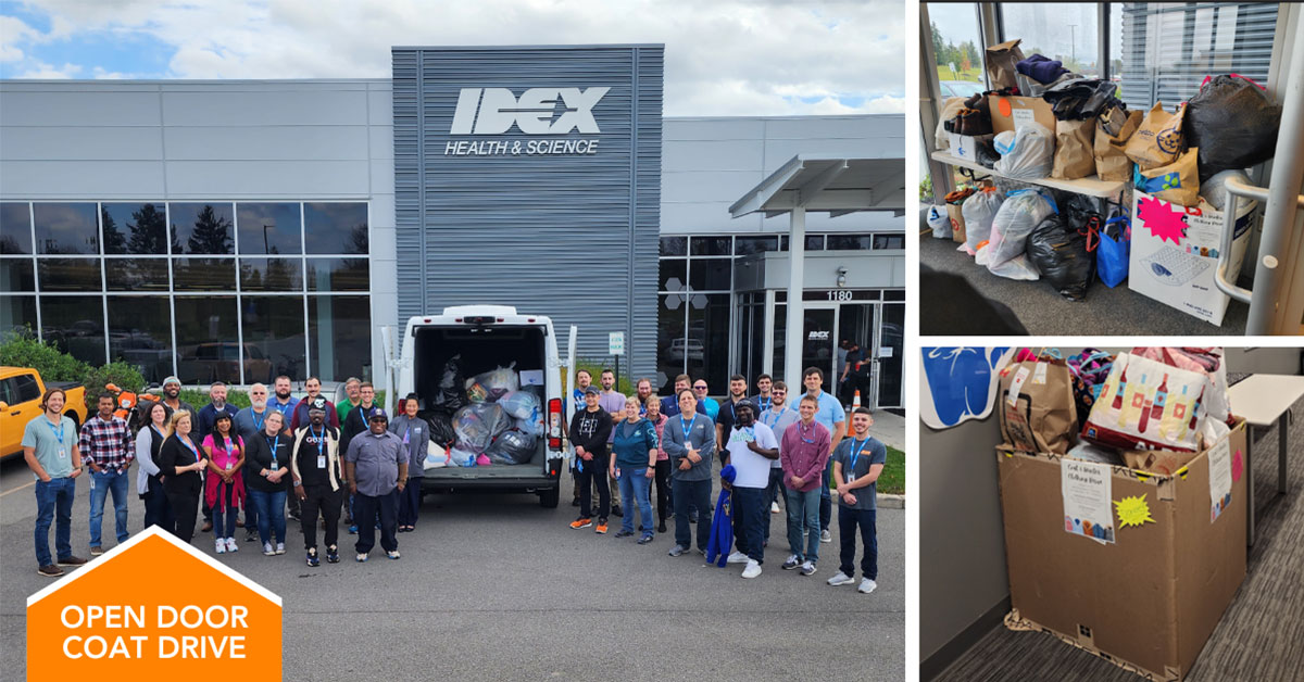 Rochester employees stand in front of 500 piece winter clothing donation