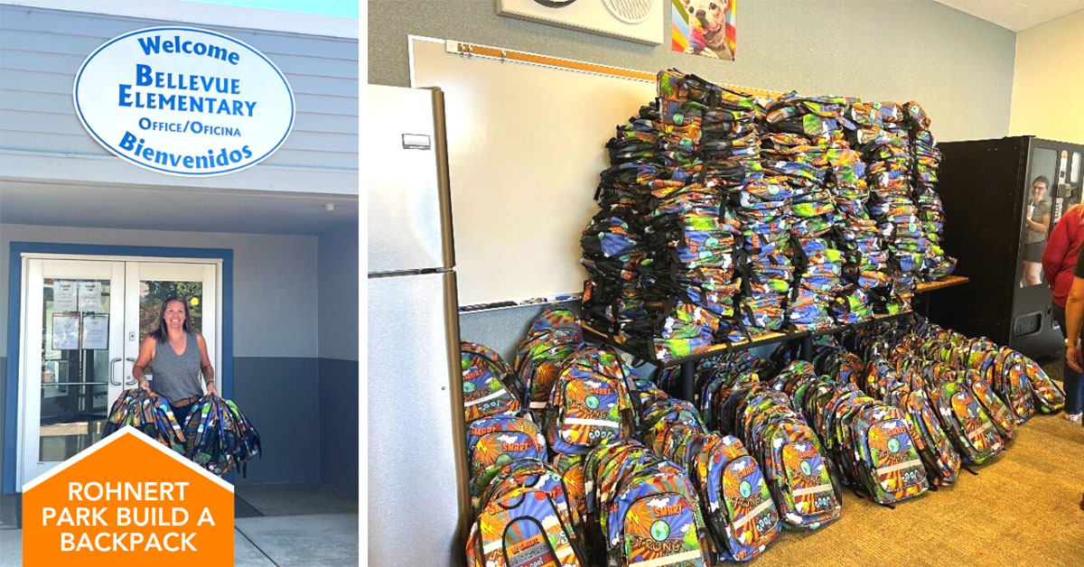 school principal poses with filled backpacks